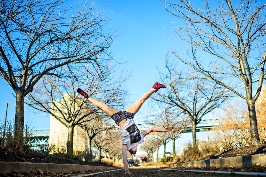 A woman doing a one handed handstand in philadelphia.